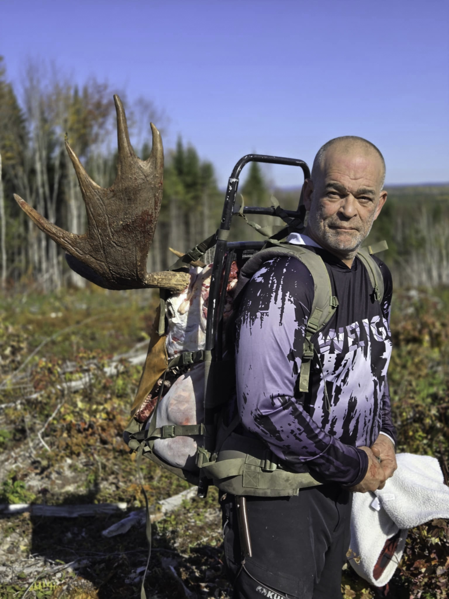 Hunter posing with harvested Maine bull moose