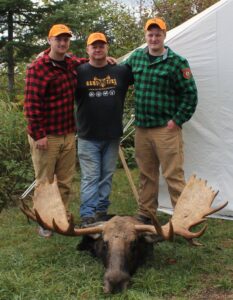 Hunter and guide posing with a mature bull moose taken during the rut